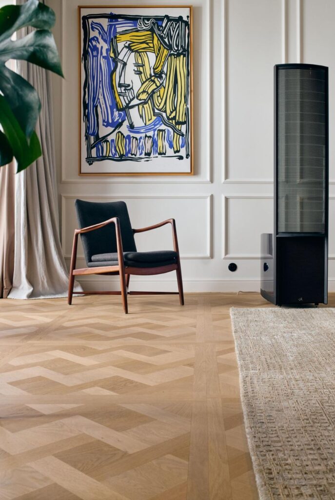 visgraat parketvloer in een stijlvol designinterieur met houten fauteuil en wandkunst